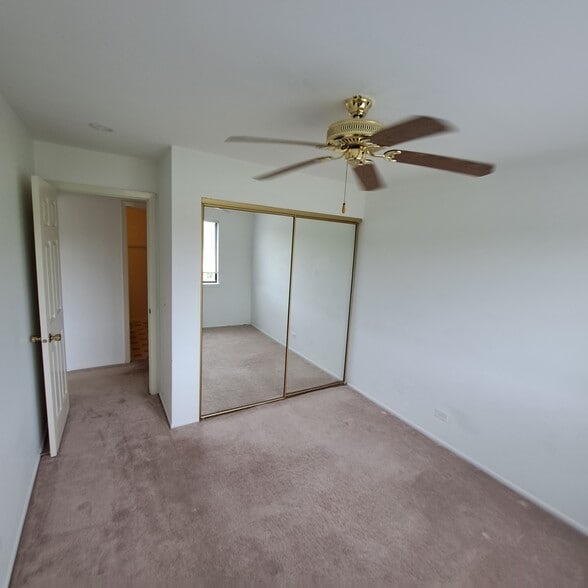 second bedroom with large closet mirrors and ceiling fan - 226 Arrowwood Ct