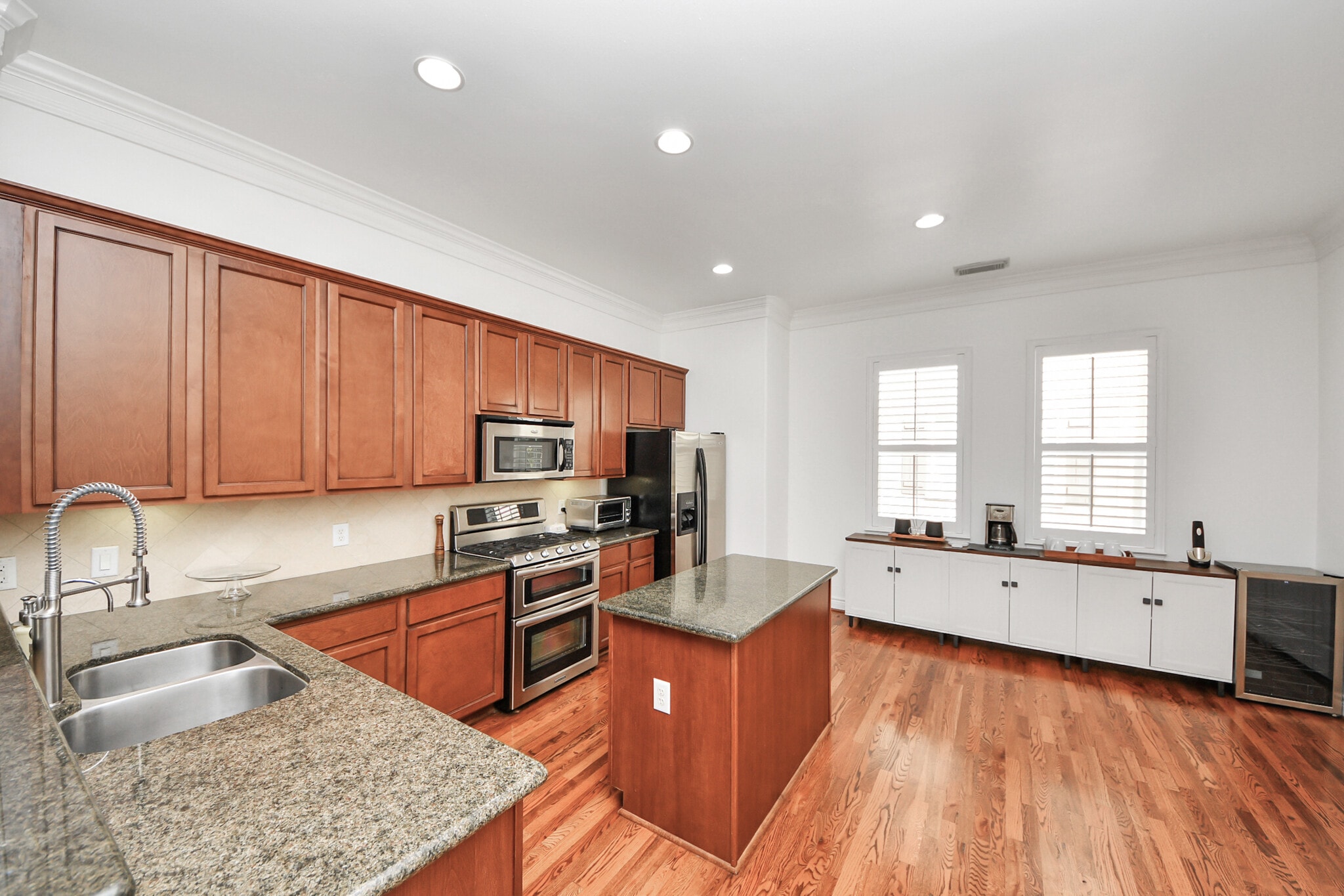 Spacious chef’s kitchen with granite counters and warm wood cabinetry. - 620 Rutland St
