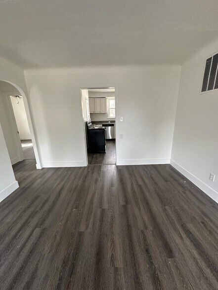 Unfurnished living room with dark wood-type flooring - 1247 N Florissant Rd