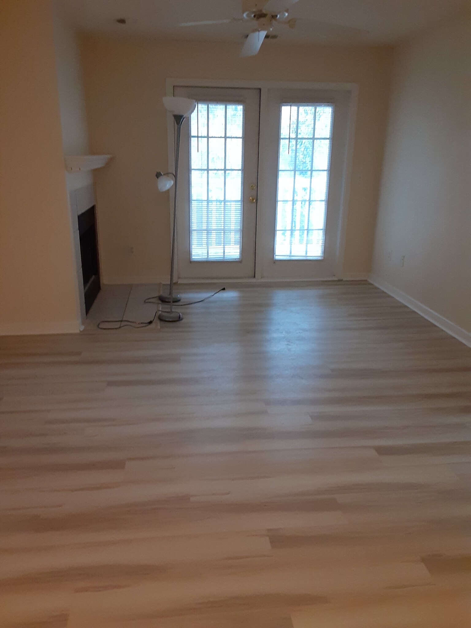 Living room with french doors, fireplace, new vinyl plank flooring - 100 Kensington Blvd
