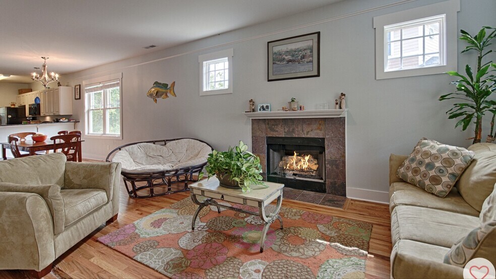 Living room with gas fireplace and hardwood floors, open to kitchen and dining - 144 Estelle Park Dr