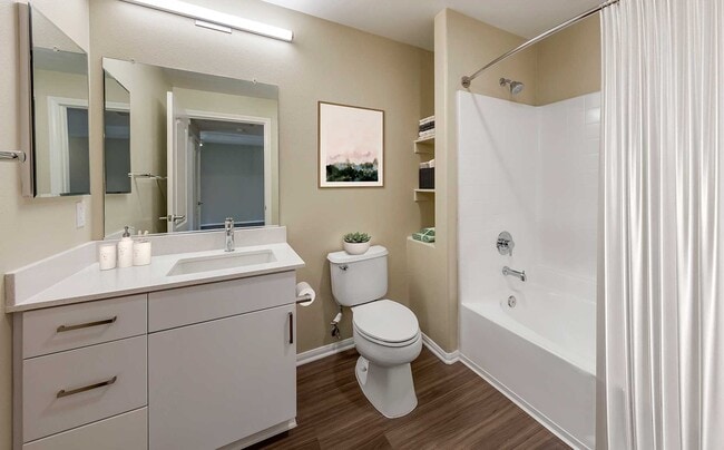 Renovated Package I bath with light grey quartz countertops, white cabinetry, and hard surface flooring - Avalon Camarillo