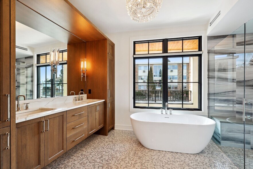 Spa-like primary bath with heated floors, dual vanity areas, large soaker tub, and curb-less walk-in - 511 2nd St