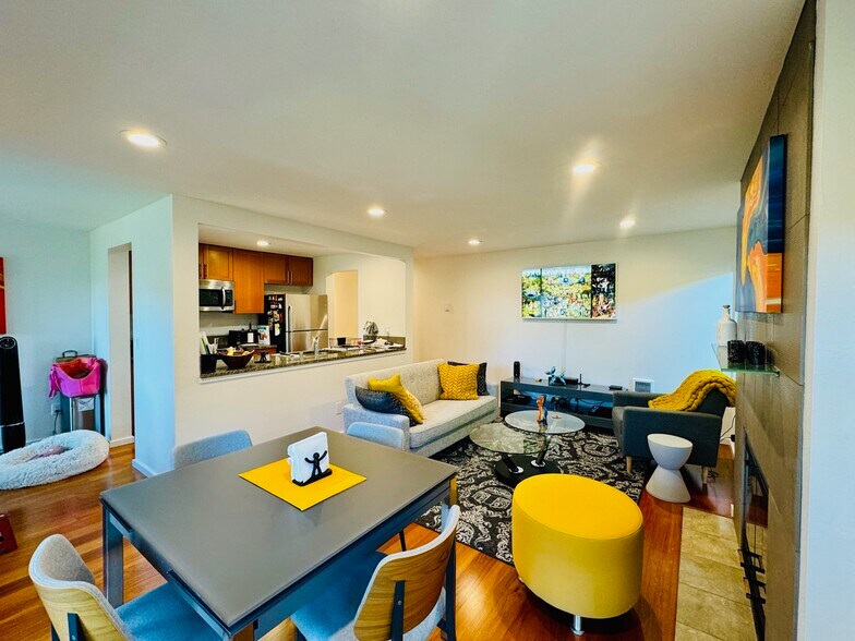 Bright and stylish open-concept living space with cozy seating, modern lighting, and warm wood floor - 2145 Dexter Ave N