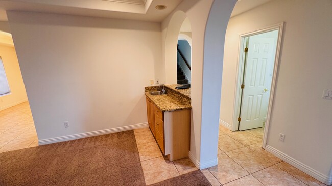 Living room equipped with a granite bar and a small sink - 2107 Plant Ave