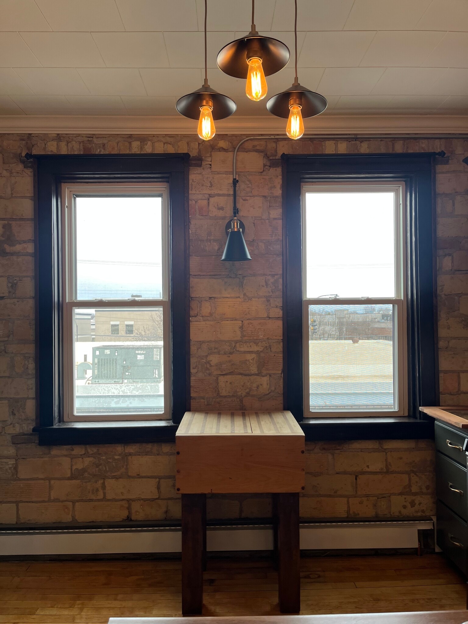Exposed brick; butcher block and wall sconce in kitchen - 415 E Saint Germain St