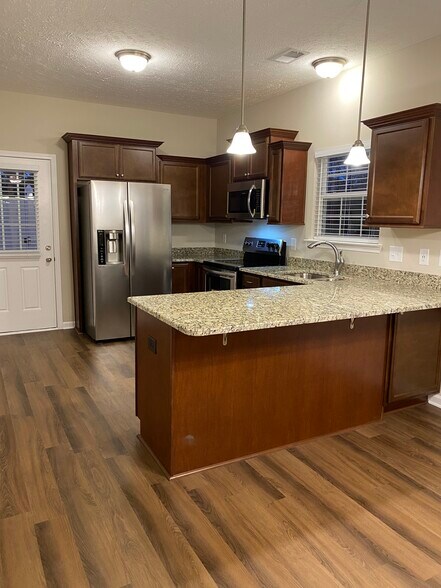 Kitchen w/ Granite Countertops, Upgraded Staggered Cabinets, Stainless Steel Appliances and a peninsula for bar stool seating - 5497 Cedar Ash Crossing