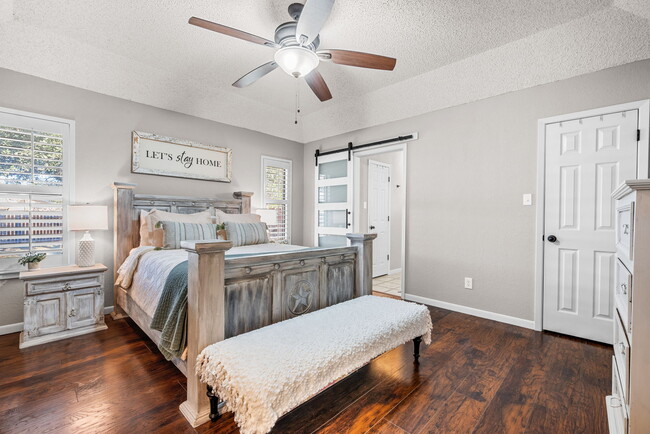 Spacious primary bedroom boasting lots of natural light, dual closets, and a modern barn doo - 209 Prairie Wind Blvd