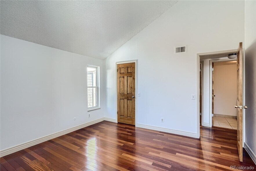 Primary bedroom with window and closet door - 14282 E Tufts Pl