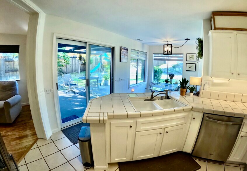 Kitchen with view of garden/playground, patio, breakfast nook, & dining room. - 4929 Chelsea Glen Ct