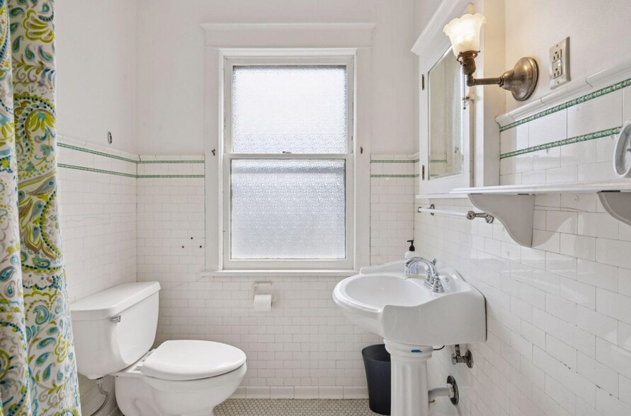 Full bathroom with detailed tilework hinting at the history of this home. Natural light is a bonus! - 2601 Portland Ave