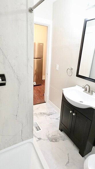 Updated bathroom. Luxury vinyl marble floors, Flexstone Glacier-Marbe shower, and new, european-styl - 4967 Lindenwood Ave