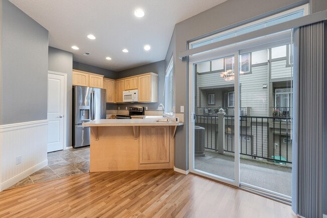 Building Photo - Lovely and bright townhouse with a hard wood flooring throughout, a 2 car garage, AC & more!