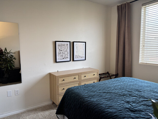 Peaceful bedroom with natural light, featuring cane dresser and minimalist artwork - 3740 Santa Rosalia Dr