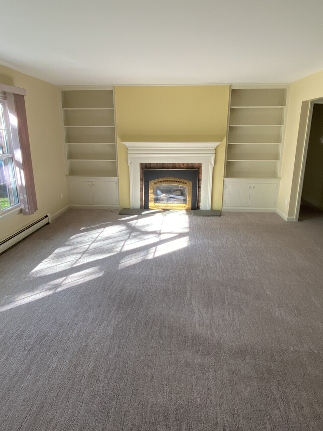 The spacious living room with fireplace and picture window overlooking courtyard - 6 Woodbrook Dr