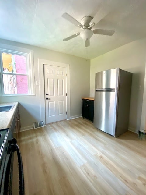 Large kitchen with new windows, flooring, microwave, and ceiling fan - 5234 Holmes St
