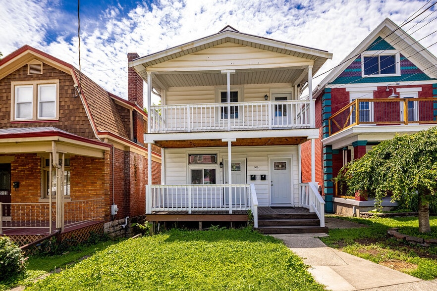 Two story duplex building with front porch and balcony - 5125 Carthage Ave