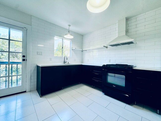 Chef's kitchen with open shelving & natural stone counter tops. - 1007 S Plymouth Blvd