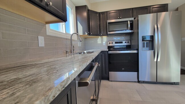 New Kitchen Cabinets and quartzite countertops. New stainless appliances. New Tile and backsplash. - 6305 49th Ave