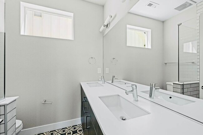 Experience luxury in this sleek bathroom with stylish modern fixtures. - Harley House