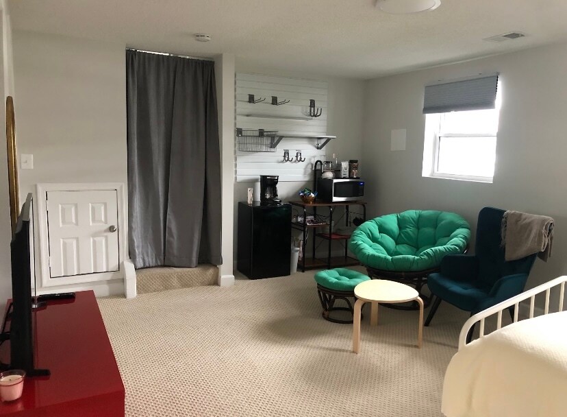 Sitting area, kitchenette, and curtains that lead to the main floor. - 7922 Fitzroy St