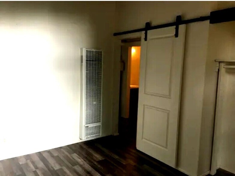 of Master Bedroom Barn Door off Bathroom. Small hall area with fan and storage shelves - 506 122nd St S