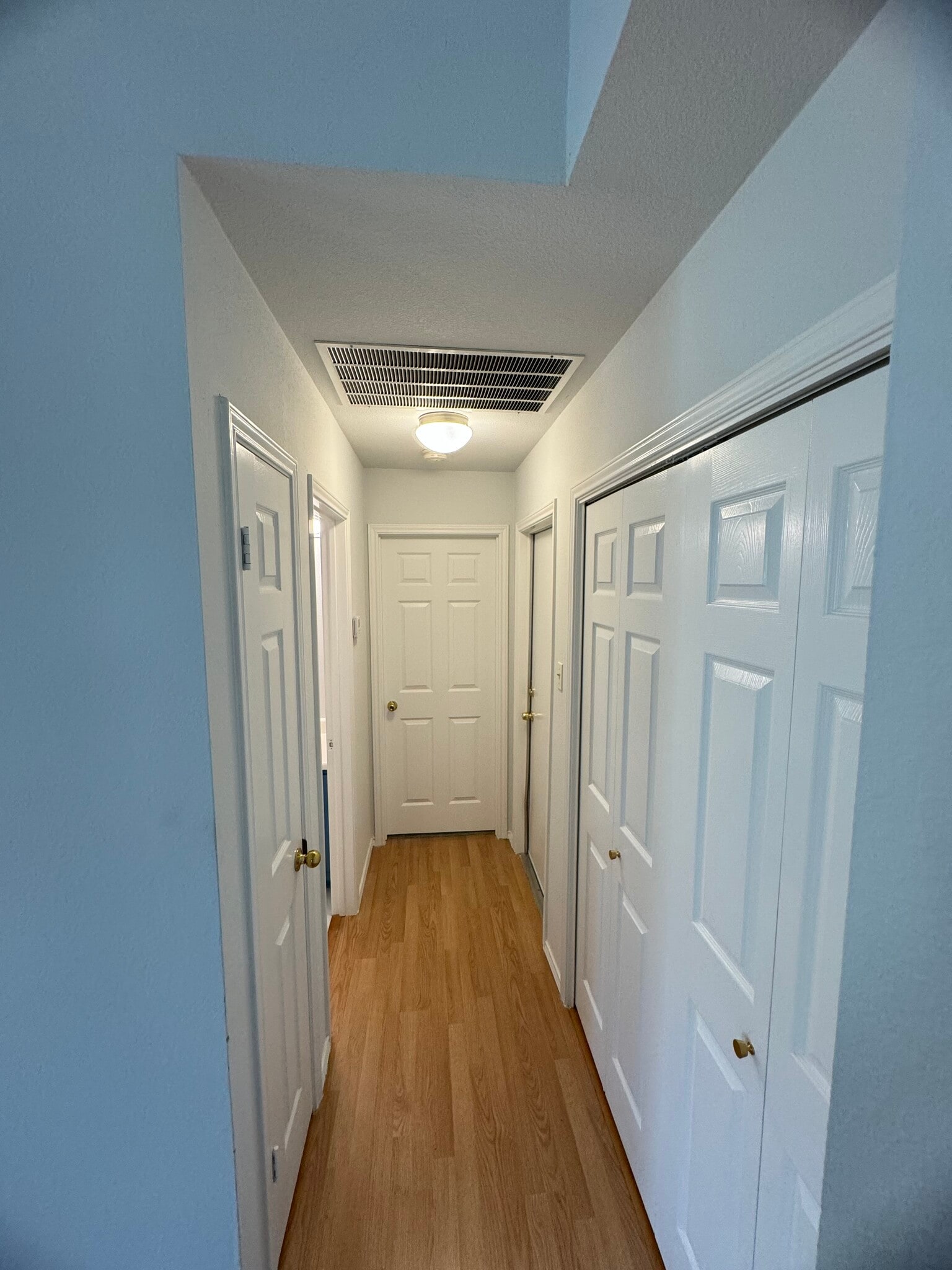 Hallway leading to: storage closet, guest bathroom, guest bedroom, garage and laundry room. - 736 Patchway Ln