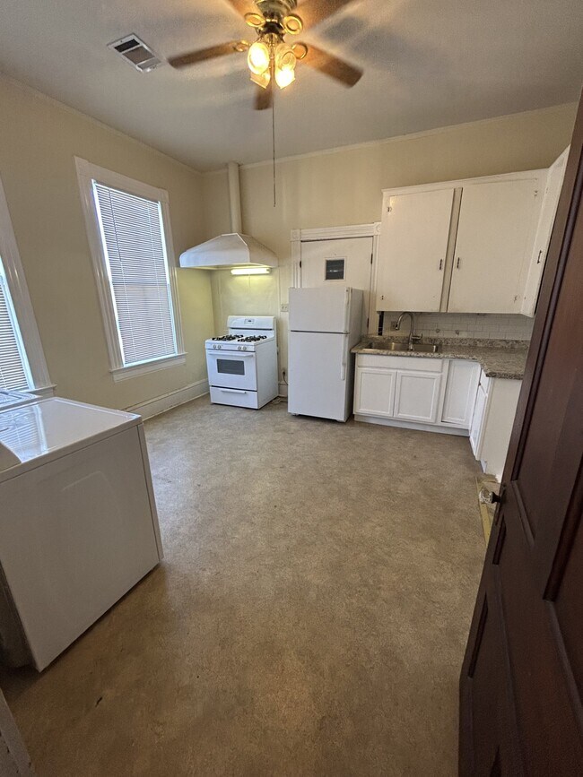 Kitchen with gas range, refrigerator and cabinets. - 1118 25th St