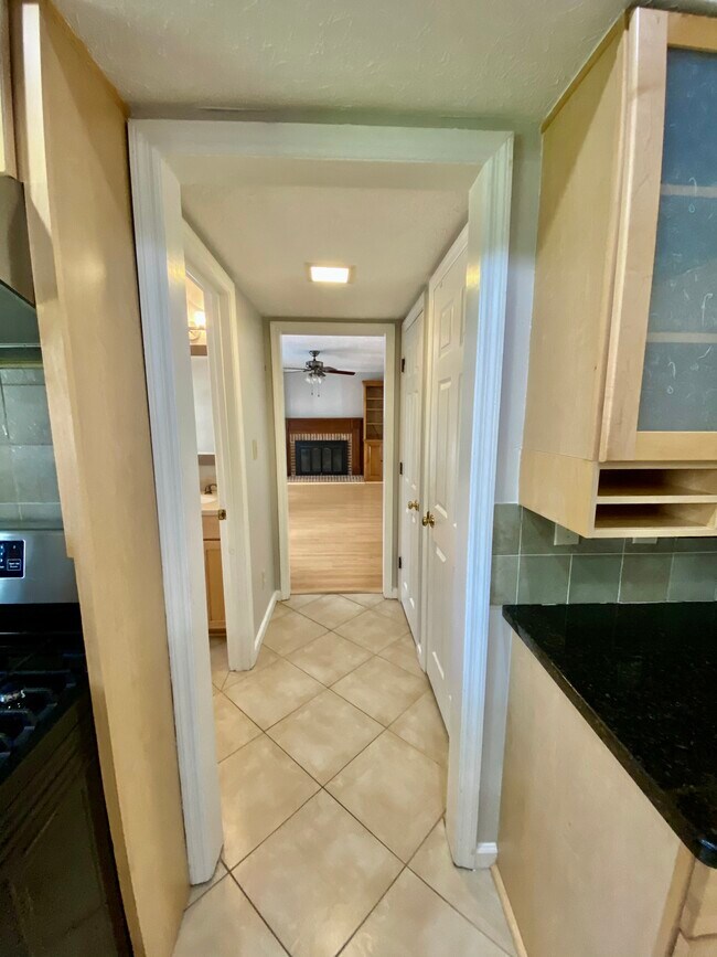 Hallway from kitchen to half bath and family room. - 2160 Heritage Trace Ln