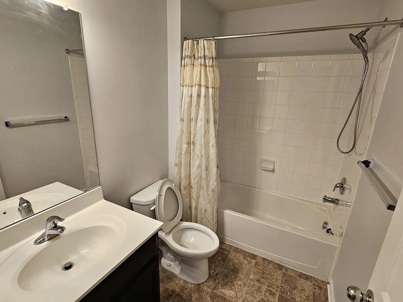 Clean full hall bathroom with tub/shower combo, tile surround, solid-surface vanity, and neutral fin - 1736 Beacon Ln