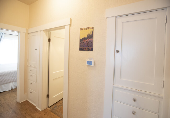 Hallway with built-in cabinets for plenty of storage. Digital thermostat. Downstairs bathroom entrance between two main level bedrooms. - 717 E Lakeside Ave