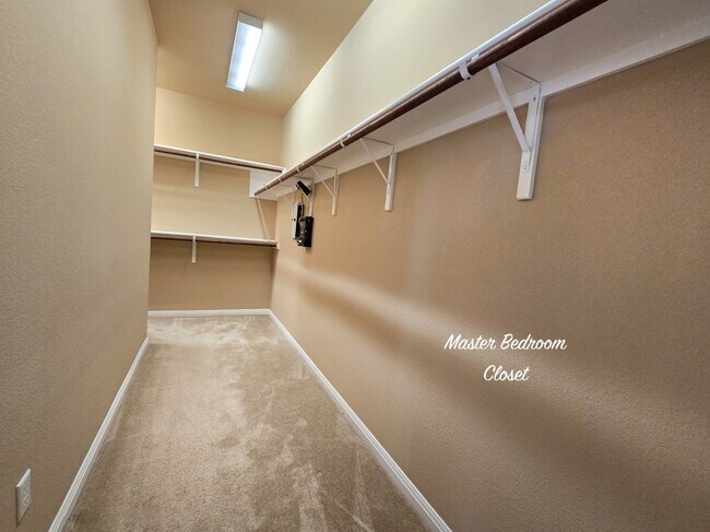 master bedroom closet is a spacious haven for your wardrobe, featuring ample hanging space - 301 Silver Trl