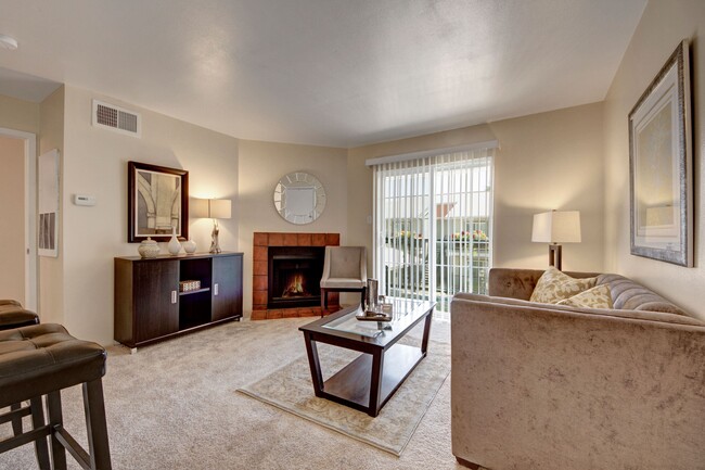 A living room with fireplace and sliding glass door out to the patio - High Plains