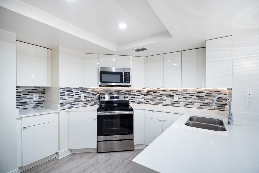 Modern kitchen with stainless steel appliances, granite countertops and designer cabinets - Waterways Village