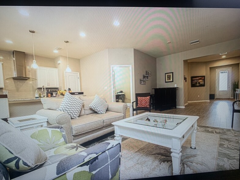 Living room open to the kitchen/pantry and office/den space. - 8012 Olive Brook Dr