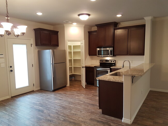 Roomy kitchen with stainless appliances, full-size refrigerator, and microwave oven. - 113 Ehlinger Dr