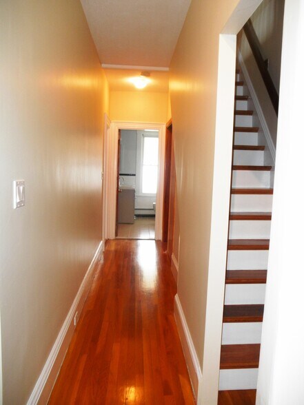 1st floor hall way view into bathroom and 2nd flr stairway - 129 Brown St
