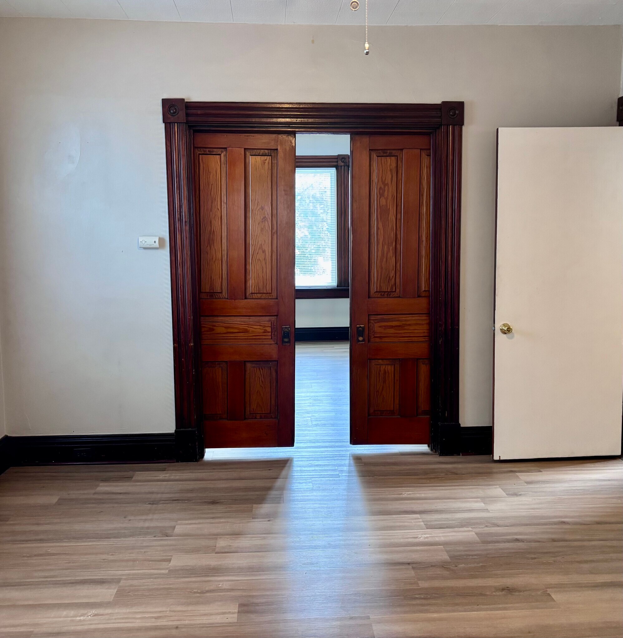 Original pocket doors separate the living/dining room space and the bedroom - 4822 Oak St