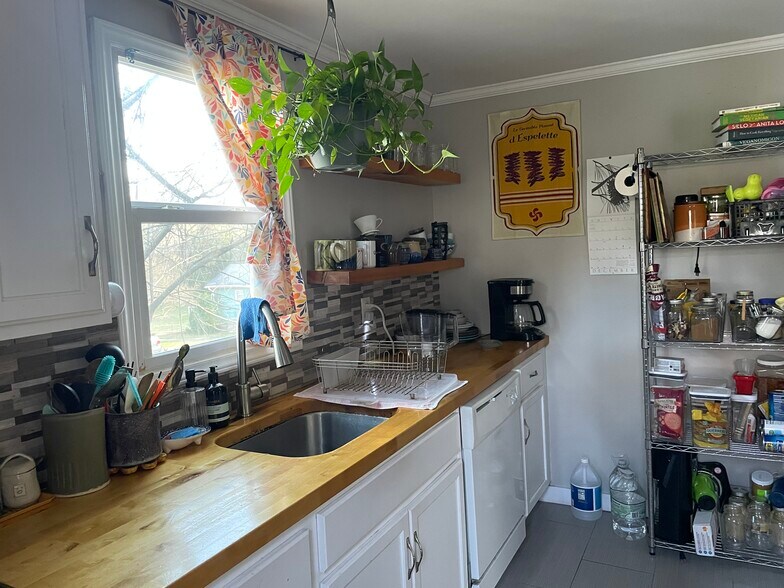Kitchen prep area with window over sink and open shelving. - 520 Commonwealth St