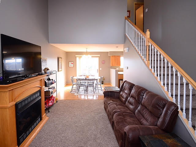 Living room with vaulted ceiling and gas fireplace. - 6965 N 88th St