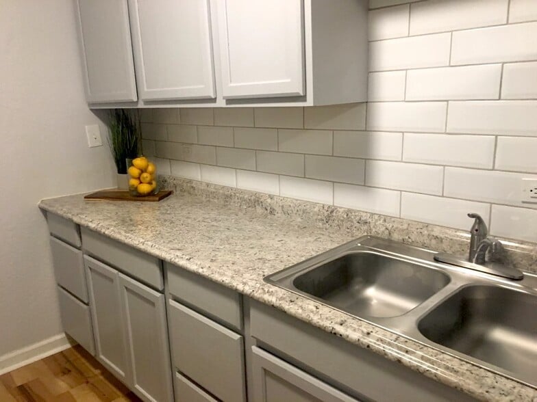 Kitchen with countertops, cabinets, beveled edge backsplash and sink. - 1439 N Olympia Ave