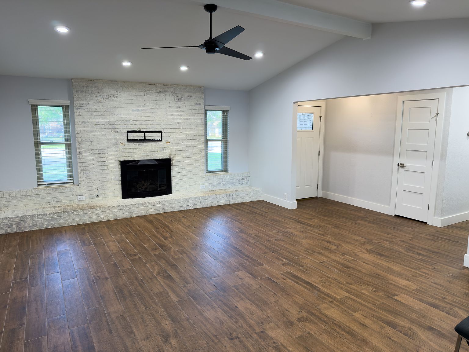 Living room featuring stone accent fireplace wall with TV mount - 2006 Candle Ct