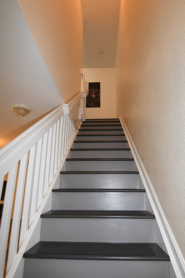 Stairs leading to isolated bedrooms on second floor. - 5036 SE Mariner Garden Cir