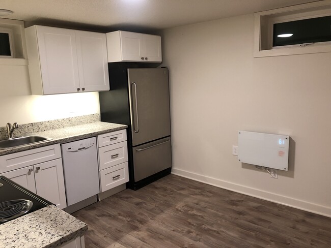 Kitchen with room for a small dining table; two windows to bring in light and plenty of countertop space and storage. - 4842 NE Mallory Ave