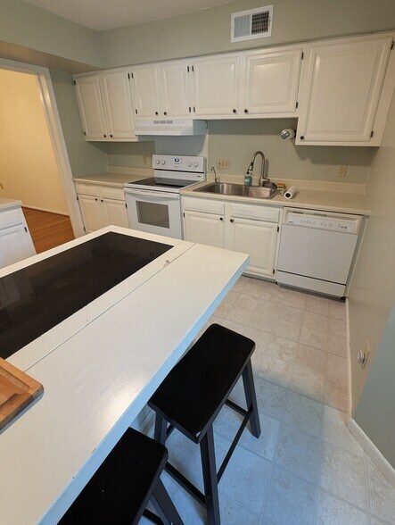Kitchen includes island with extra storage/counter space and bar stools - 4 Chelsea Cir
