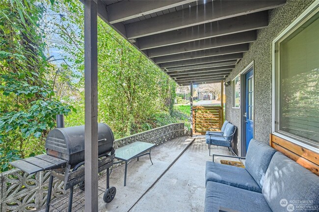 Patio with furniture, grill, and creek. - 1045 NE 115th St