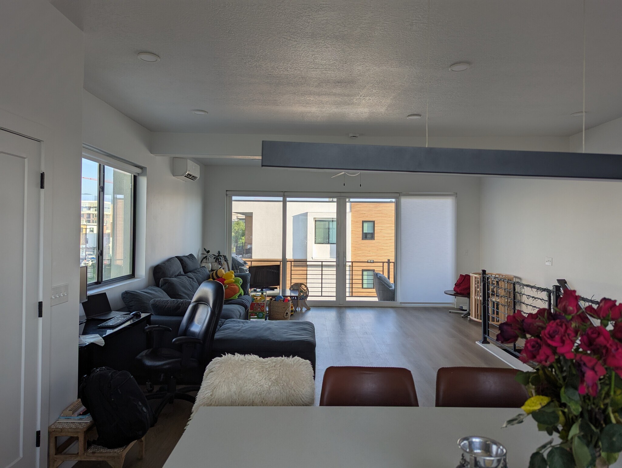 Living room with a ceiling fan, light wood-style flooring, recessed lighting, and a wall mounted air - 44 W Iko Ave