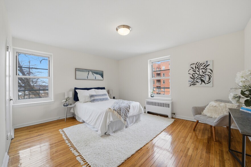 Spacious primary bedroom with two windows, including one overlooking the Hudson River. - 555 Broadway