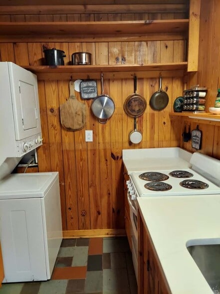 Detail of kitchen with range/oven, spices, pans, washer/dryer - 311 Newton Aly