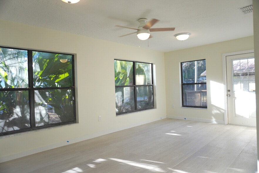 Spacious sun-filled living room with fans and outdoor access for Yankeetown gatherings. - 33 63rd St